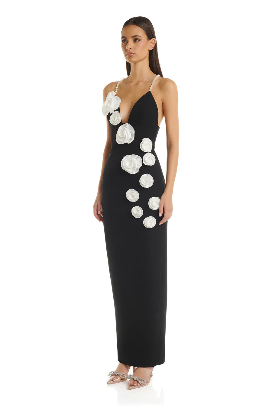 Side view of a black evening gown with a backless design, pearl-strap details, and stretch fabric for a figure-hugging fit.