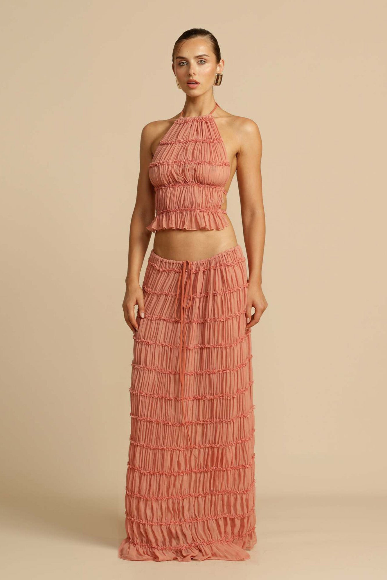 Front view of the Pink Chiffon Backless Lace-up Pleated Maxi Dress, showcasing the elegant pleated design and hanging neck style.