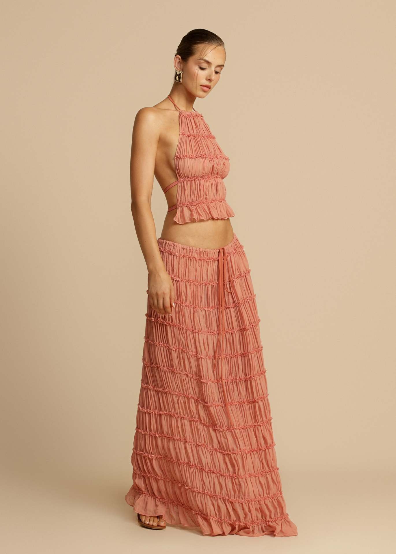 Side view of the Pink Chiffon Backless Lace-up Pleated Maxi Dress, highlighting the flowing pleats and flattering silhouette.
